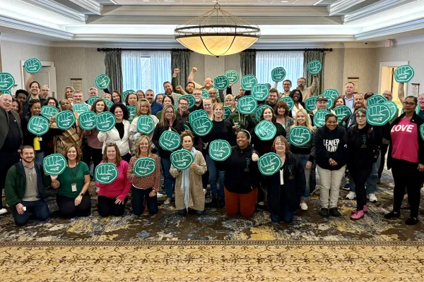 group photo people holding up green foam fists
